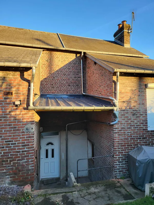 Auvent couvert en zinc au-dessus d'une porte d'entrée