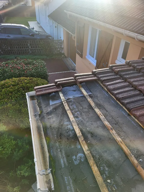 Gouttière encombrée au bas d'une toiture en tuiles