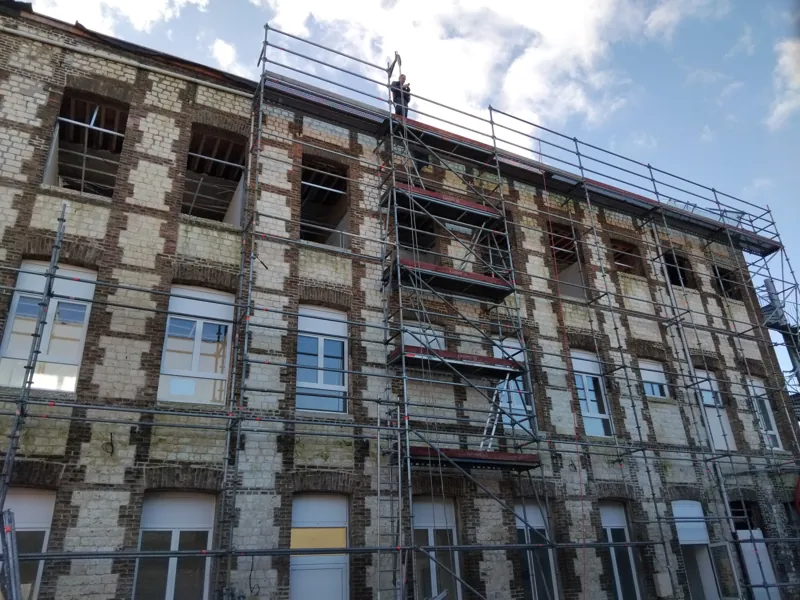 Immeuble en brique sous échafaudage pour travaux de toiture