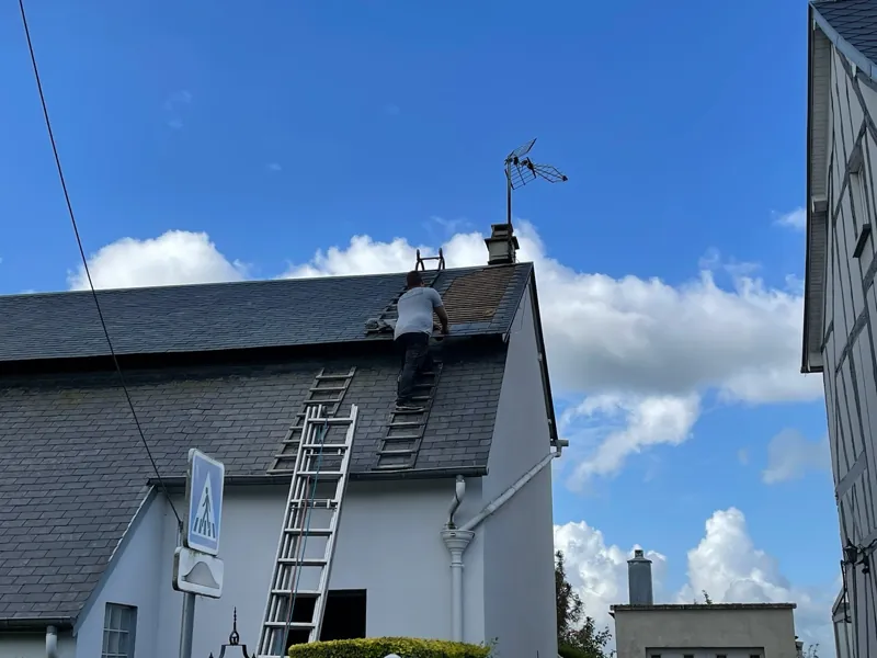Maison couverte en ardoise, échelle posée contre la façade