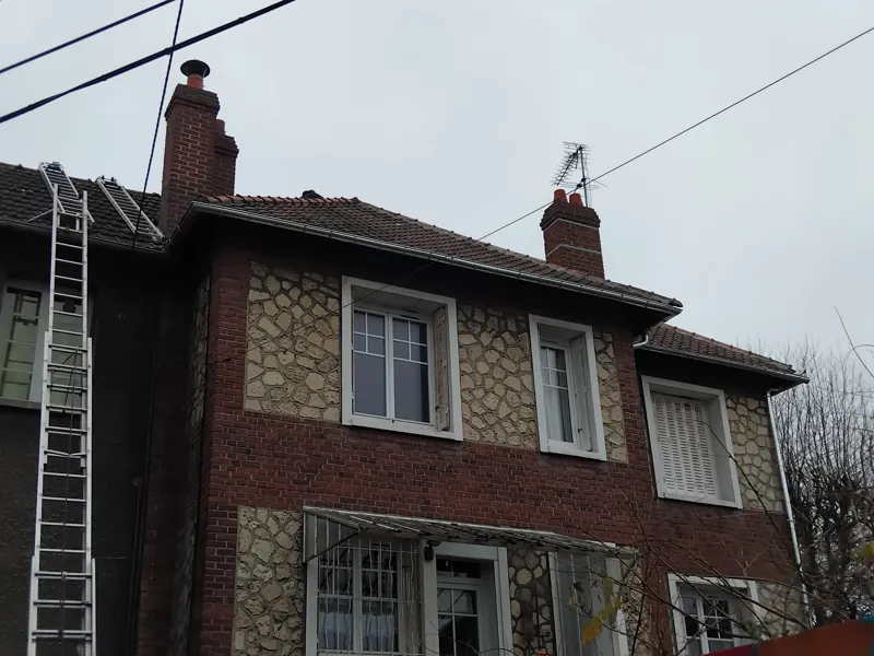 Maison normande en brique et silex, échelle contre la façade