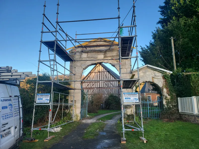 Échafaudage monté autour d'un portail ancien en pierre