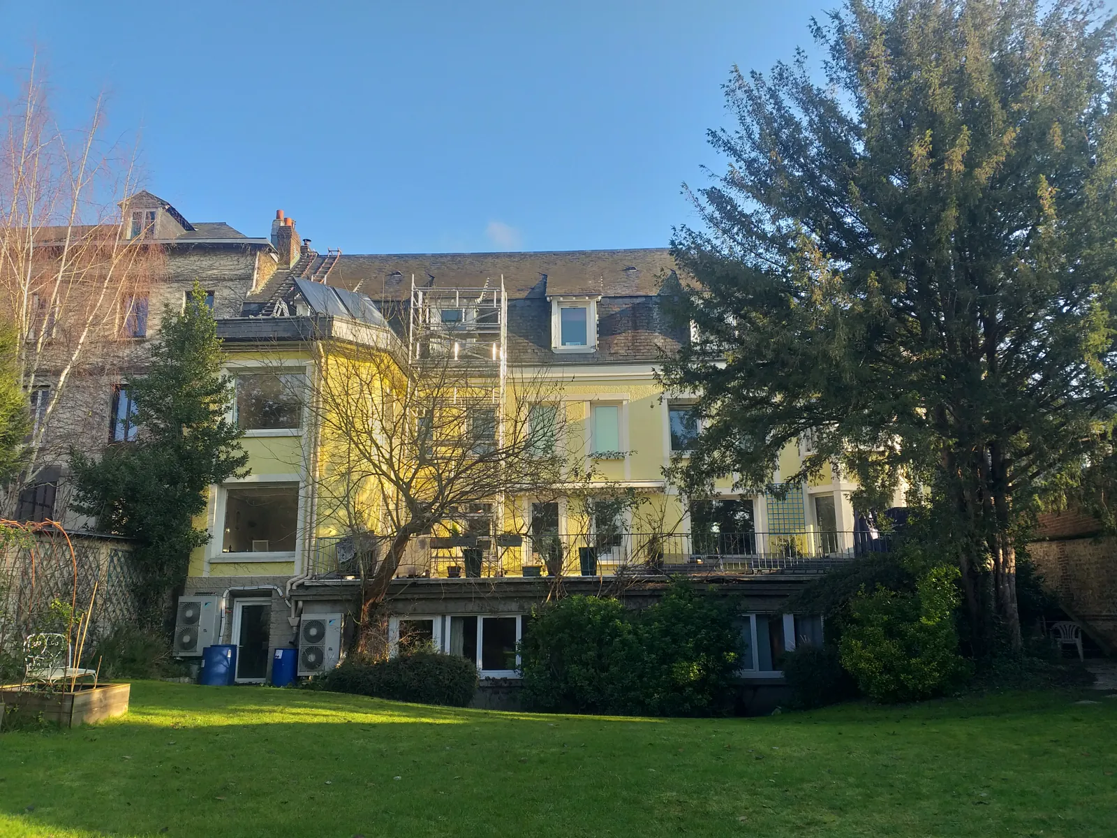 Résidence ancienne et ses toitures vues depuis le jardin