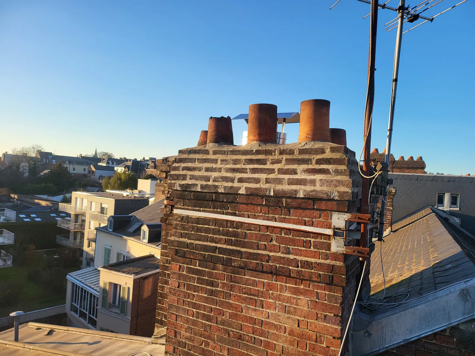 Souches de cheminée en brique au-dessus des toits de la ville